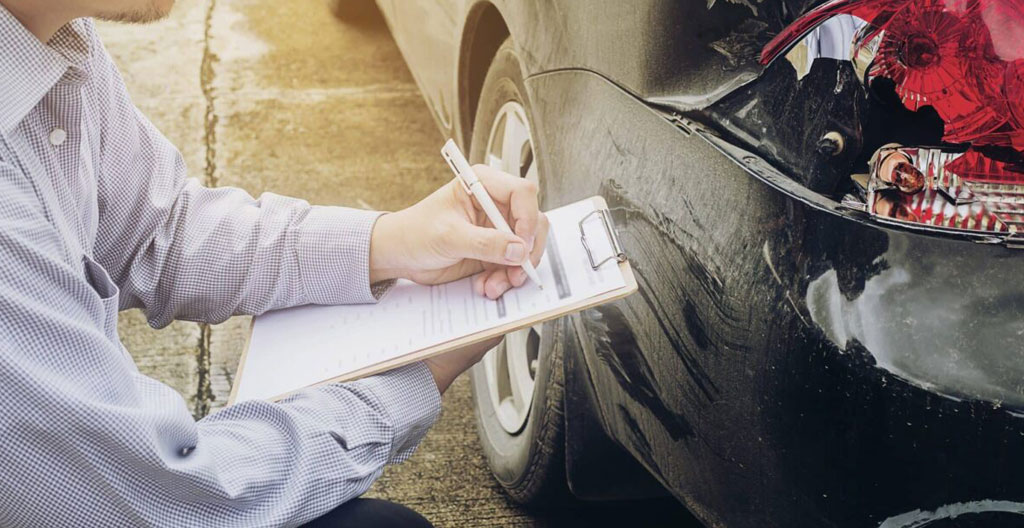 Document de police d'assurance automobile posé sur un bureau, montrant les sections de tarification